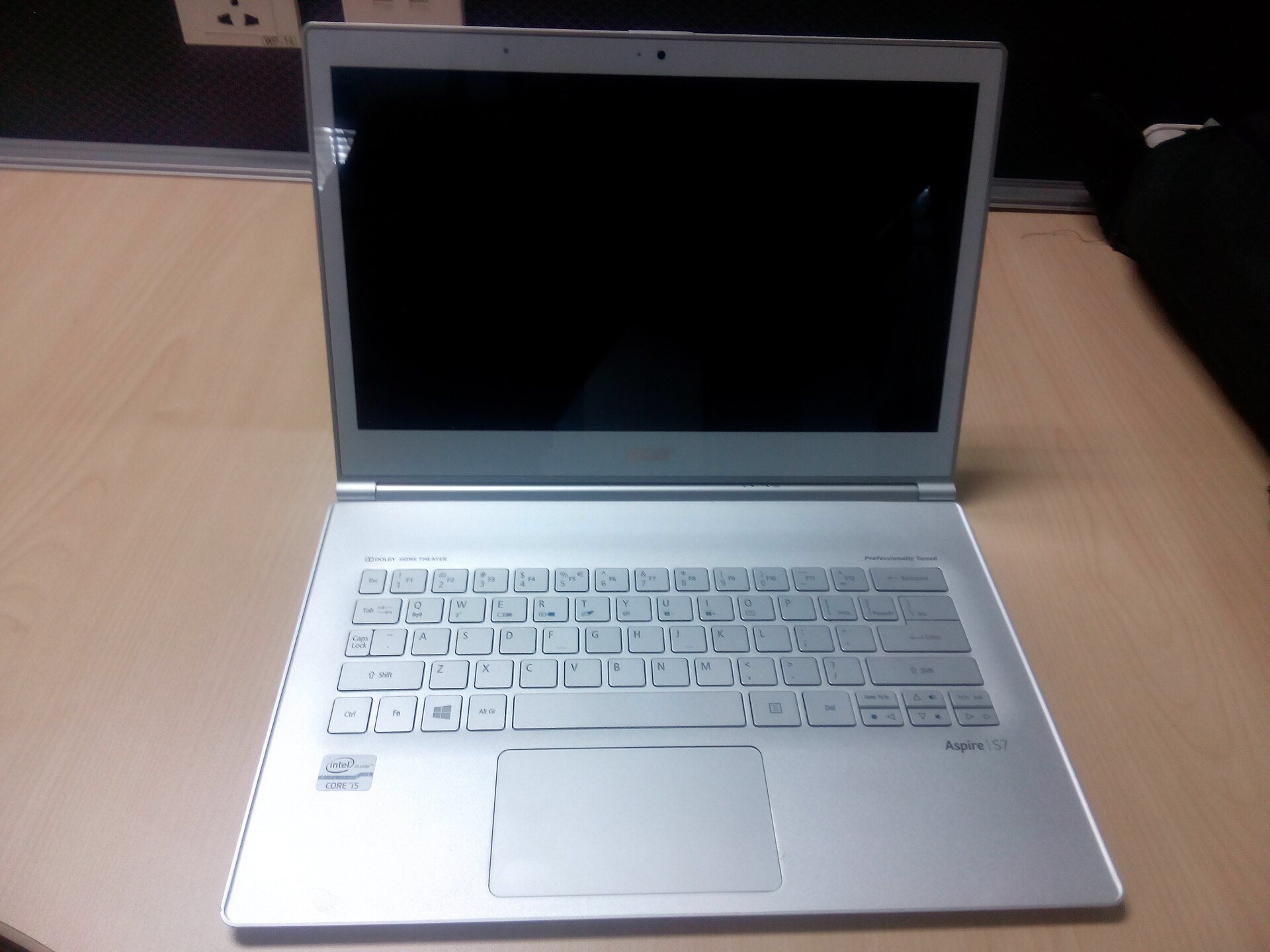 An open silver laptop on a light wooden desk